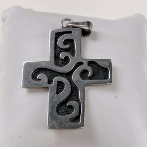 Large sterling silver cross pendant, black background.